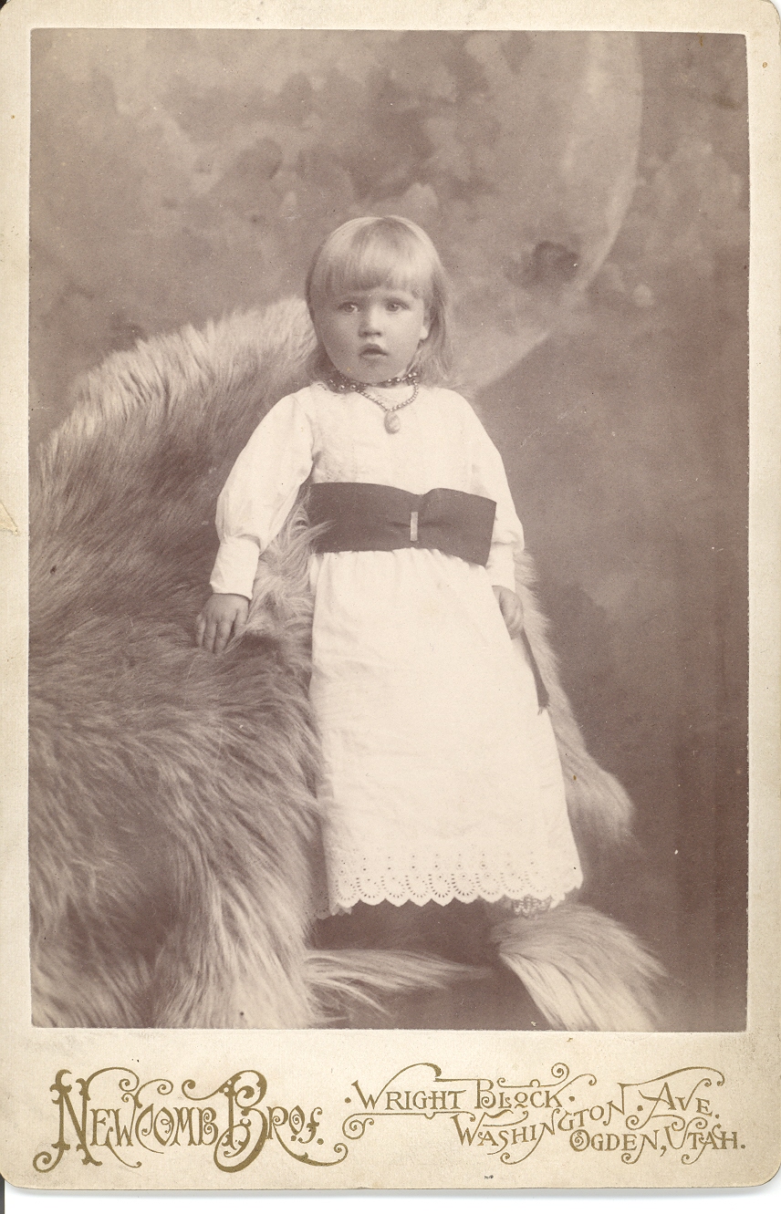 unidentified blonde child leaning on bear rug
